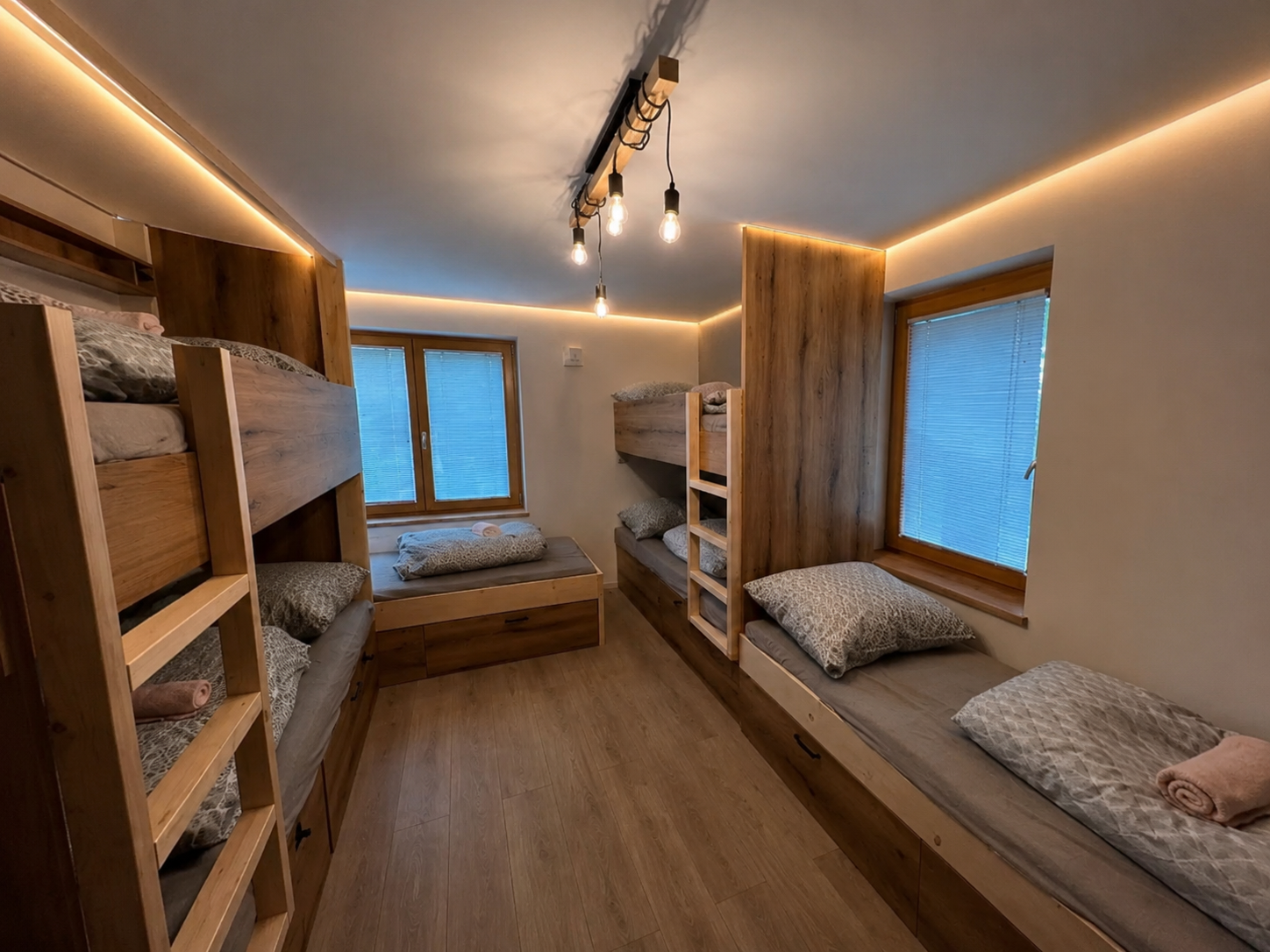 Bunk room with warm LED lighting and windows